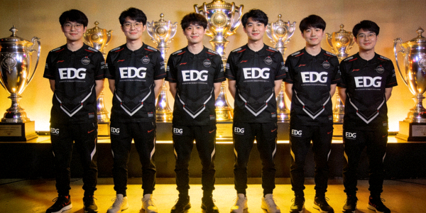 EDG电子竞技俱乐部英雄联盟分部团队合影 - 队员身着黑色队服，背景是冠军奖杯